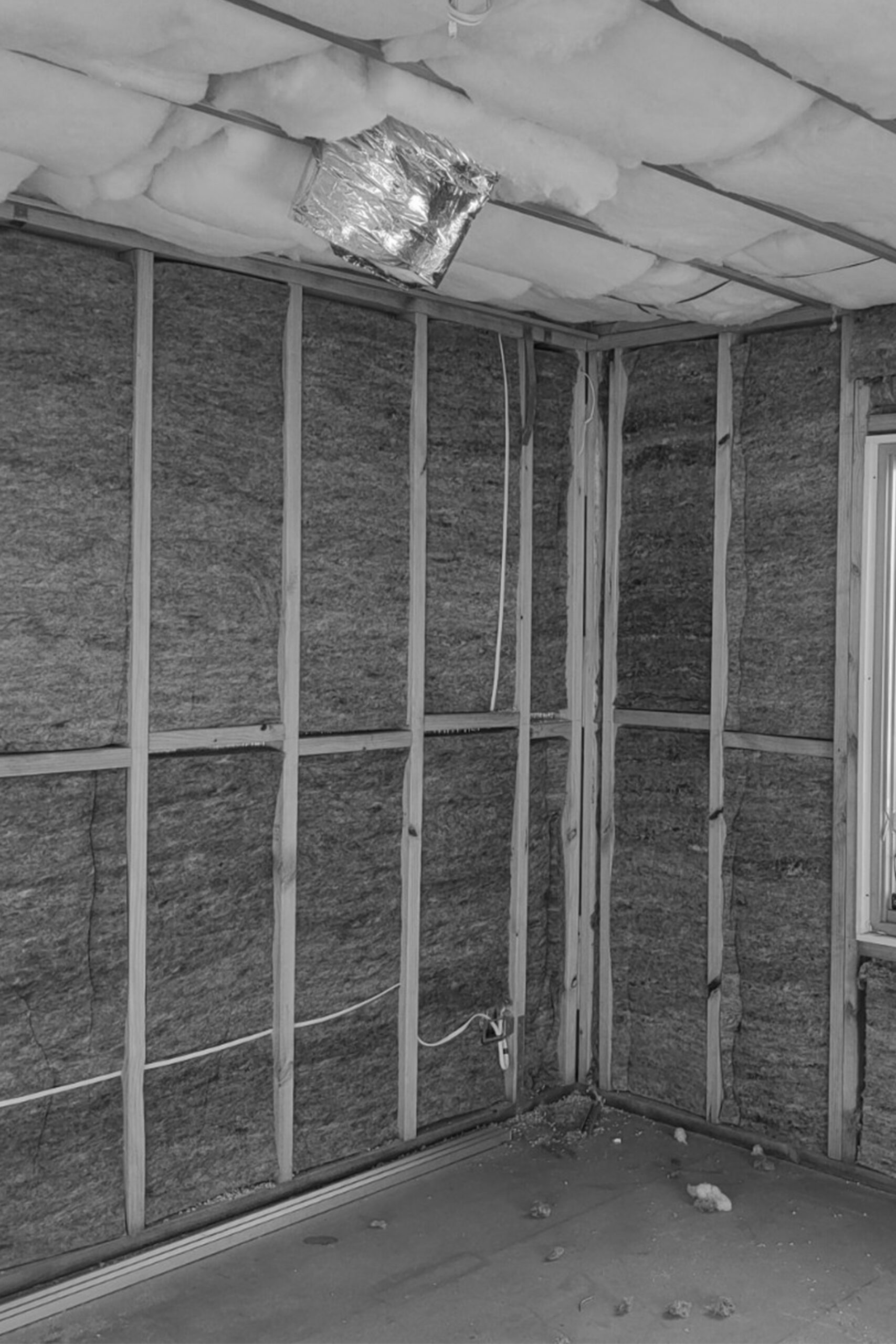 mid-project showing exposed timber framing, wall insulation, and services prior to sheeting.